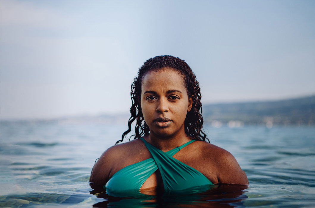 Amana Beachwear, eine Frau mit einem grün/türkisen Bikini Oberteil ist zusehen wie sie aus dem Wasser kommt, Sportswear