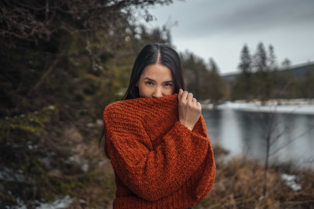 Living Crafts, Eine frau in rotem Strick-Pullover vor einer herbstlichen Landschaft, Womenswear, Unisex