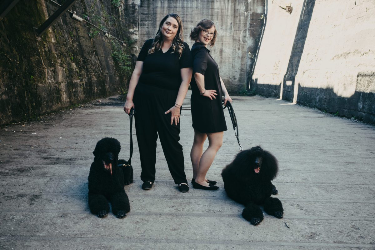 esthétique, zwei Frauen in schwarzer Kleidung und zwei schwarzen Hunden an der Leine sind zusehen, womenswear