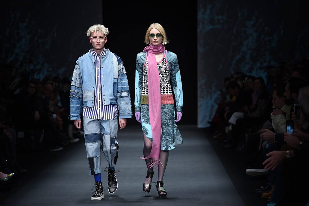Zwei Models auf einem Laufsteg, Outfits im Jeans-Patchwork-Look