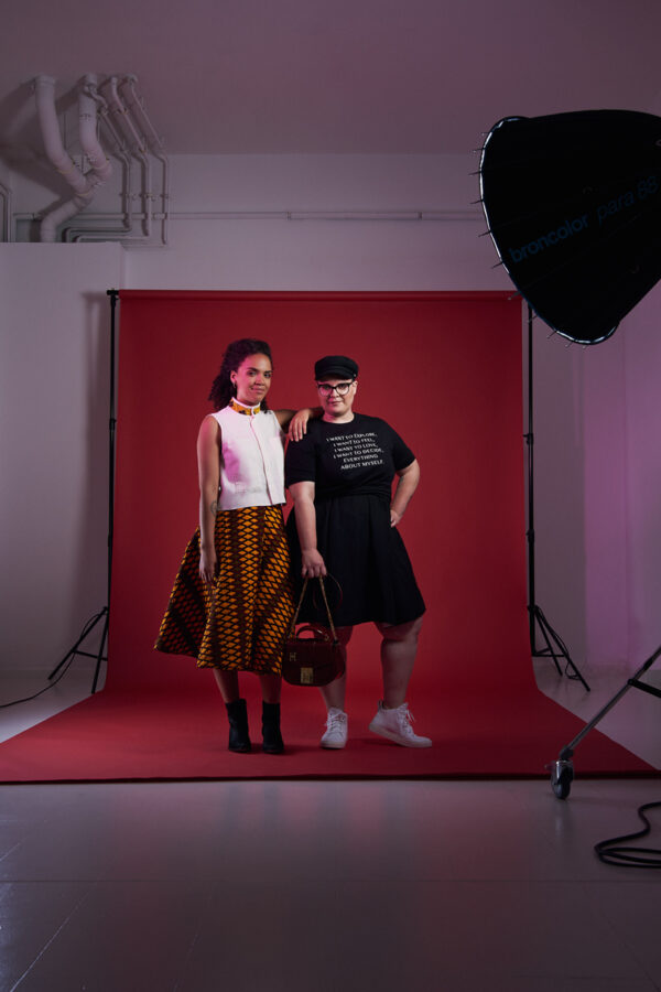 Ciani Hoeder und Brit Morbitzer stehen nebeneinander, sie sind bei einem Fotoshooting und sie tragen modische Fair Fashion Marken, das Bild ist aus dem Buch „Fashion Changers“