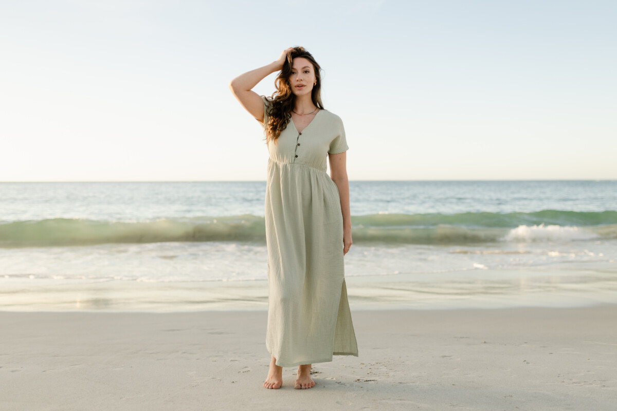 NORDLICHT, eine Frau vor einem Strand in einem hellgrünen Sommerkleid, Womenswear.