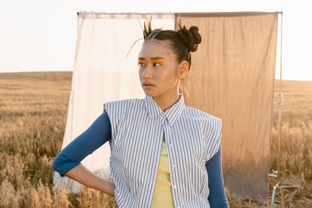 Membership April: Person steht auf einem Feld, dahinter wehen zwei Vorhänge