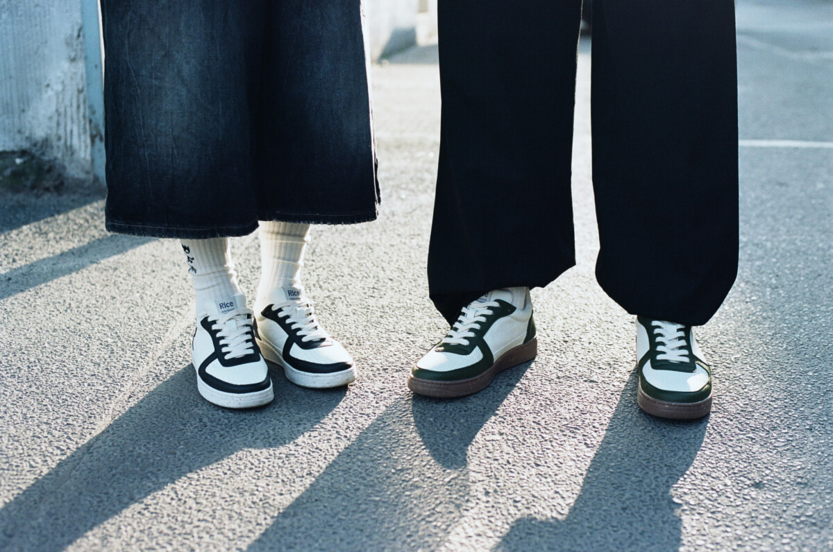 Rice, Auf Asphalt stehen zwei Models in Jeans Rock und Hose, welche minimalistische Sneaker mit weißen Socken tragen, Schuhe, Unisex.