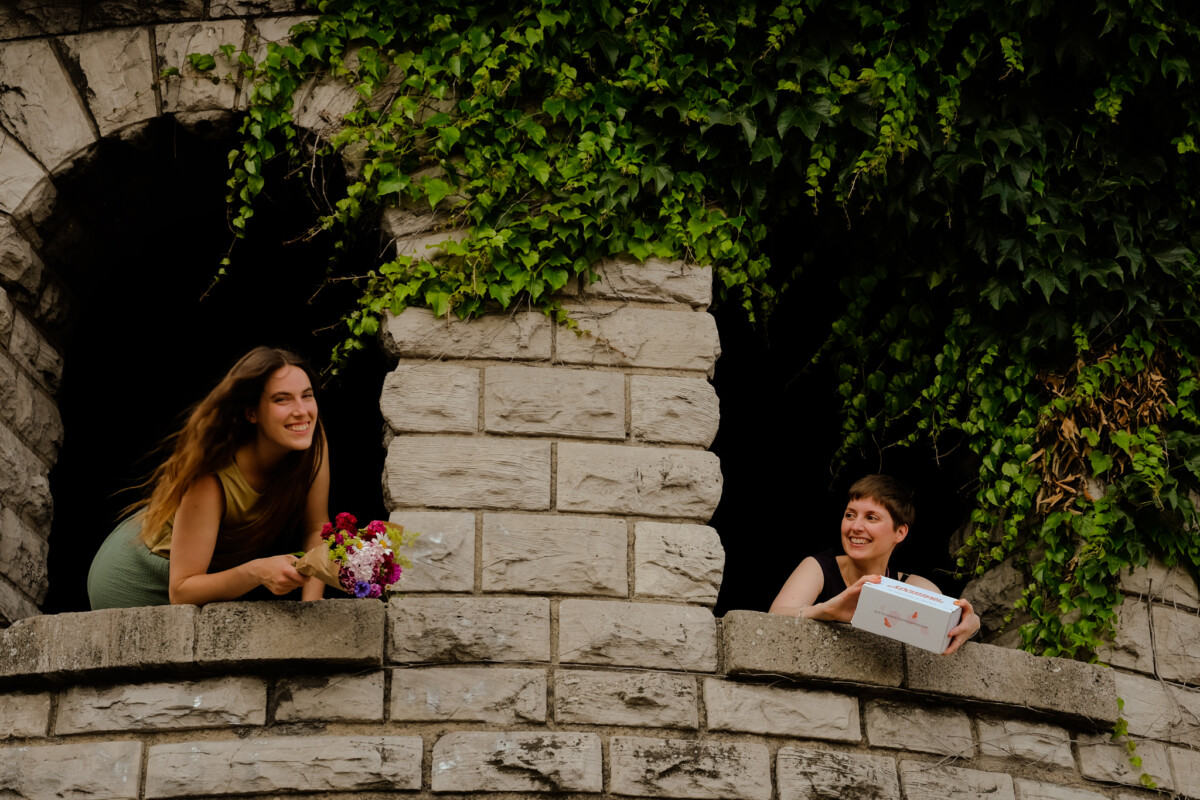 Sommerbox Gewinnspiel, in einem Turmfenster ist eine Person kit der Fashion Changers Sommerbox und eine zweite Person sitzt in einem anderen Fenster.