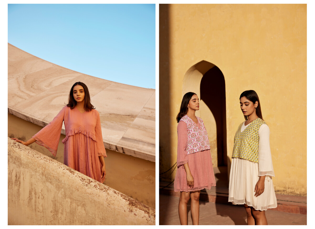 Ïmaima: drei Frauen posieren in leichten, pastellfarbenen, gerafften Kleidern vor einem historischen Sandsteingebäude.