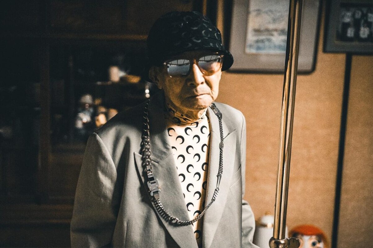 Der Japaner Tetsuya Kudo zeigt, dass Mode in jedem Alter Spaß macht. Er trägt einen grauen Blazer, ein Oberteil mit Halbmonden sowie Mütze und Sonnenbrille.