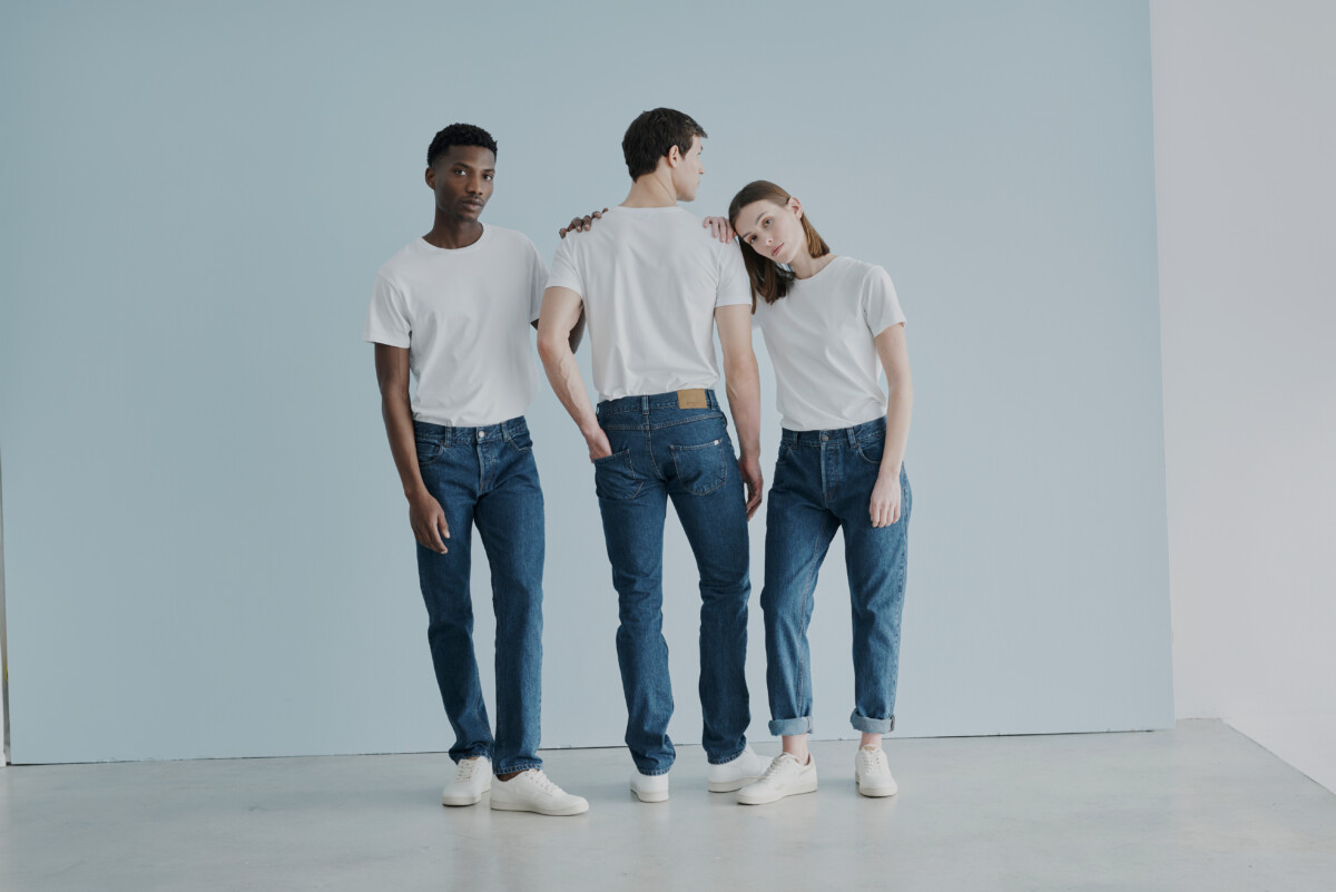 SANVT – The Perfect Jeans: Drei Personen stehen vor einem weißen Hintergrund; sie tragen weiße T-Shirts, Turnschuhe und Bluejeans.